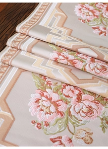 Detail der rosa Pfingstrosenstickerei und Goldmuster auf beigefarbenem Satin-Tischläufer