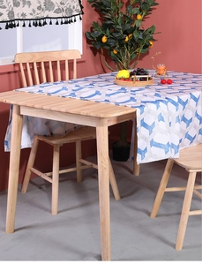Detailed view of blue and white geometric linen tablecloth on a natural wooden dining table