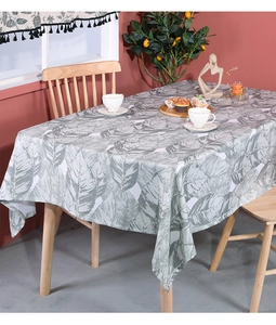 Detail of linen tablecloth with grey-green leaf patterns and refined fabric texture