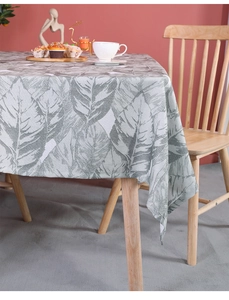 Detail of tropical large leaf print on grey-green linen textured tablecloth