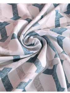 Detail of linen tablecloth with teal geometric Y-pattern and woven fabric texture