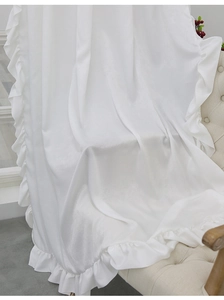 Detail of white velvet curtain with ruffled edge draped elegantly on a stylish sofa chair