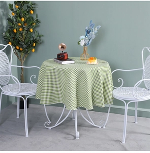 Close-up of green and white plaid cotton linen tablecloth on a round dining table