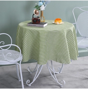 Macro shot of green and white plaid cotton linen fabric texture on a round tablecloth