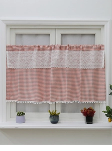 Detailed close-up of pink checkered cafe curtain with crochet lace and white pom pom trim