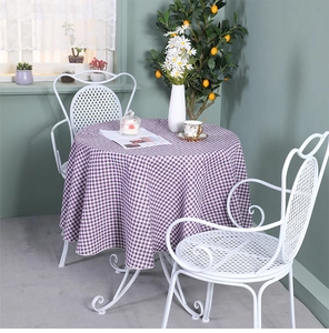 Close-up of a purple and white checkered round tablecloth on a white dining table