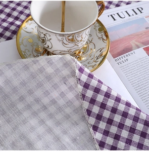 Detailed view of purple plaid cotton linen fabric with refined stitching and weave texture