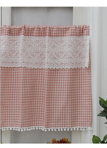 Detail of red checkered cafe curtain with white floral lace and plush pom-poms