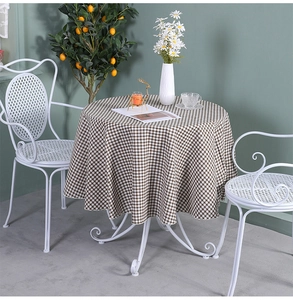 Close-up of brown and white checkered linen tablecloth on a white patio round table