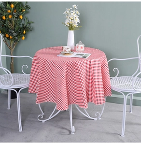 Detail of red and white gingham round tablecloth in a cozy indoor afternoon tea setting