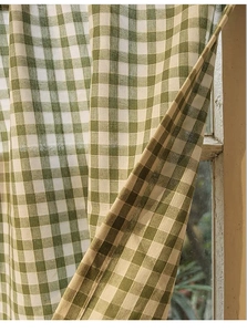 Close-up of green and white gingham fabric texture on a vintage wooden window frame