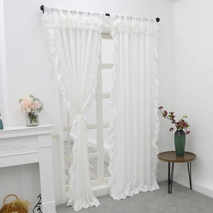Elegant white velvet curtains with ruffled edges hanging in a minimalist French style room