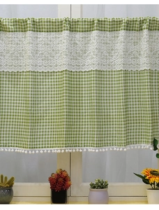 Detail view of green plaid cafe curtain with lace patchwork and white pom-pom fringe decor