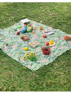 Detailansicht der wasserdichten Picknickdecke mit grünem Blumenmuster und Lilien-Print