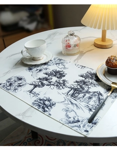 Detail of blue floral pattern placemat with linen texture on marble table