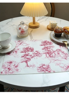 Detail of red toile de jouy pattern on waterproof linen placemat with fine stitched edges