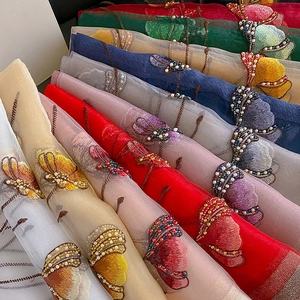 Detail of embroidered silk blend scarf with delicate pearl beadwork in multiple colors