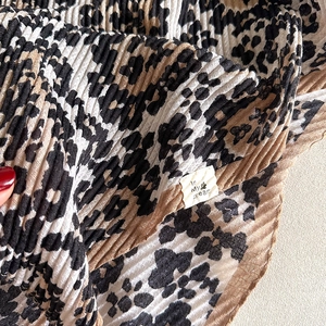 Detailed close-up of leopard print pleated scarf fabric with In My Dream brand label