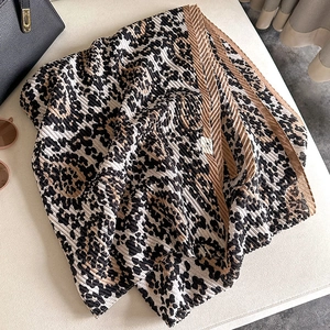 Close-up of pleated leopard print scarf with detailed texture and classic animal patterns