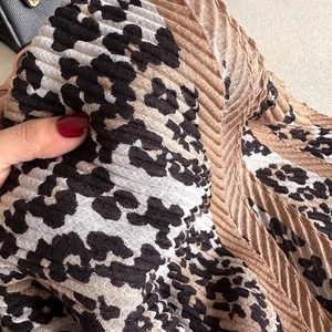 Close-up of leopard print crinkled fabric showing detailed pleated texture and soft material