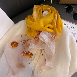 Detail of yellow silk blend scarf featuring tulip embroidery and pearl bead accents
