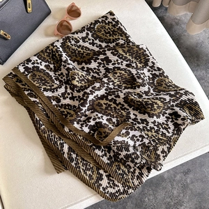 Detail of leopard print pleated cotton linen scarf with soft texture and refined folds