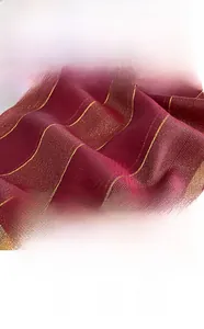 Dettaglio del tessuto bordeaux effetto seta con strisce dorate e trama perlata