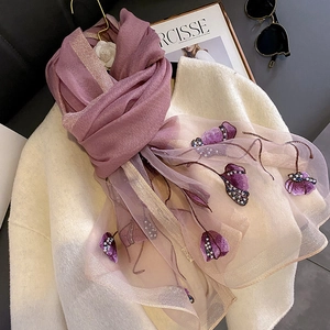 Detail view of purple silk scarf featuring 3D floral embroidery and faux pearl embellishments