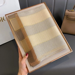 Dettaglio della sciarpa in seta a righe con fili metallici in elegante confezione