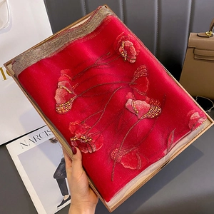 Detail of red silk scarf featuring exquisite 3D floral embroidery and gold bead accents