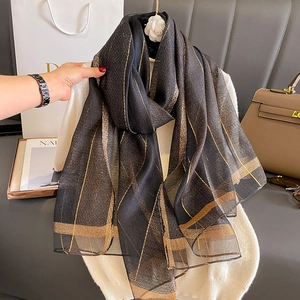 Elegante sciarpa nera e oro con strisce metalliche scintillanti e raffinato motivo a quadri