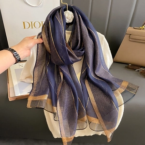 Dettaglio della sciarpa in chiffon blu navy con eleganti strisce dorate sottili