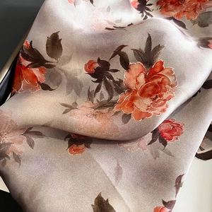 Dettaglio ravvicinato di una sciarpa in seta con elegante stampa floreale di peonie