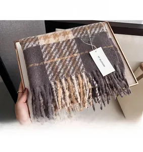 Detailaufnahme der exquisiten Quastenkante und weichen karierten Stoffstruktur am Schal