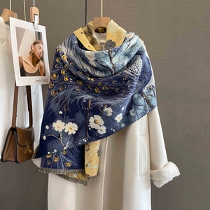 Dettaglio dello scialle vintage con motivo a piume di pavone e frange sul cappotto