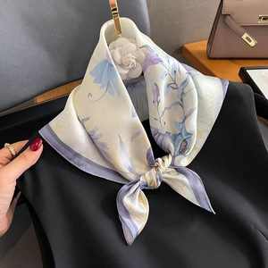 Élégant foulard en soie aux motifs de lilas porté sur un col noir avec accessoires
