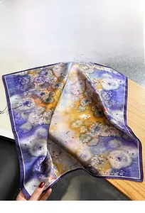 Détail d'un foulard en soie vintage avec motifs floraux abstraits violets et oranges