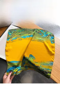 Macro detail of silk scarf showing vintage landscape patterns with yellow and teal colors