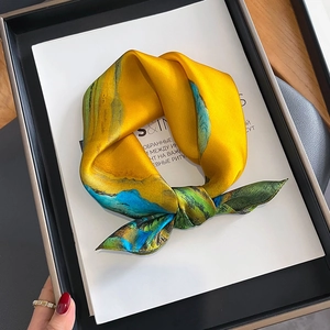 Detail of silk scarf with artistic green mountain print folded in a knot shape