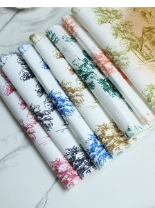 Close-up of layered linen-cotton napkins with vintage landscape print and stitched edges