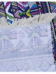 Detailed macro of Bohemian woven picnic mat showing geometric patterns and white fringe
