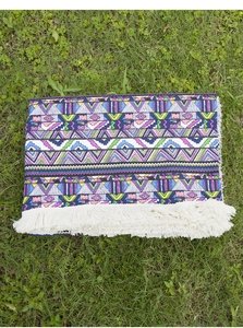 Detail of bohemian outdoor picnic mat with colorful geometric waves and white tassels