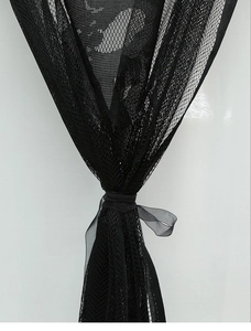 Detail of black mesh lace curtain with a silk ribbon tie for Halloween party decor