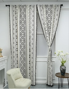 Detail of black and white geometric pattern on bohemian linen curtain with fringe