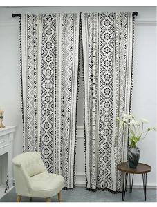 Detail of bohemian geometric print kitchen curtain with black fringe on cotton linen fabric