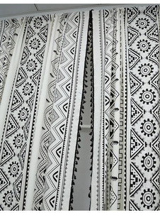 Detail of bohemian black and white geometric pattern curtain with black fringe tassels