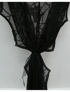 Detail of black lace Halloween curtain with spiderweb and bat patterns in soft mesh fabric