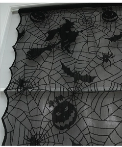 Detail of black lace Halloween curtain with spiderweb, witch and pumpkin patterns