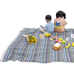 Bohemian woven picnic blanket with geometric patterns and fringe for outdoor camping