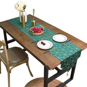 Deep green velvet table runner with gold geometric diamond pattern and white tassels